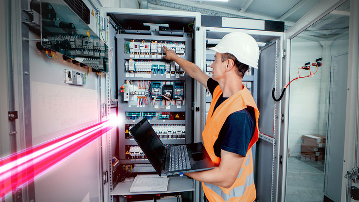 Gebäudetechnik effizient planen mit EPLAN - Techniker vor Schaltschrank